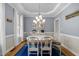 Elegant dining room featuring a white oval table, chandelier, and blue accent rug at 5125 Salinas Ct, Holly Springs, NC 27540