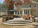 The exterior of this home features a tiered stone patio with seating and outdoor dining area at 5125 Salinas Ct, Holly Springs, NC 27540