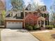 Traditional brick home with a three-car garage, dormer windows, green shutters, and a beautiful tree in the front yard at 5125 Salinas Ct, Holly Springs, NC 27540