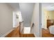 Upstairs hallway with wood floors, white walls, and doors leading to multiple rooms at 5125 Salinas Ct, Holly Springs, NC 27540