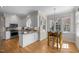 Open kitchen with white cabinets, granite countertops, and an adjacent breakfast nook with natural light at 5125 Salinas Ct, Holly Springs, NC 27540