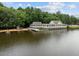 Lakeside view of a lake house, dock, and lush green surroundings at 5125 Salinas Ct, Holly Springs, NC 27540