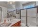 Bright bathroom with a large mirror, frosted glass enclosed shower, a window, and wood vanity at 5595 Godwin Lake Rd, Benson, NC 27504