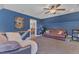 Bonus room boasts blue accent walls, plush seating, neutral carpet, and a ceiling fan at 5595 Godwin Lake Rd, Benson, NC 27504