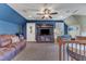 The bonus room includes plush seating, a ceiling fan, TV cabinet, and blue accent wall at 5595 Godwin Lake Rd, Benson, NC 27504