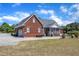 Brick home featuring a screened porch, attached garage, and an extended driveway, surrounded by green lawn at 5595 Godwin Lake Rd, Benson, NC 27504