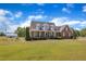 Charming two-story brick home featuring a welcoming front porch, manicured lawn, and a detached garage at 5595 Godwin Lake Rd, Benson, NC 27504