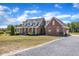 Charming two-story brick home featuring a welcoming front porch and a gravel driveway at 5595 Godwin Lake Rd, Benson, NC 27504