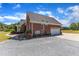 The home has a connected garage, a gravel driveway, and brick exterior at 5595 Godwin Lake Rd, Benson, NC 27504