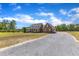Charming two-story brick home featuring a welcoming front porch and a gravel driveway at 5595 Godwin Lake Rd, Benson, NC 27504