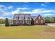 Charming two-story brick home featuring a welcoming front porch and manicured lawn at 5595 Godwin Lake Rd, Benson, NC 27504