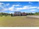 Charming two-story brick home featuring a welcoming front porch, manicured lawn, and a long driveway at 5595 Godwin Lake Rd, Benson, NC 27504