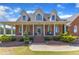 Charming red brick home boasts a welcoming front porch, well-manicured landscaping, and classic architectural details at 5595 Godwin Lake Rd, Benson, NC 27504