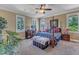 Inviting main bedroom features an ornate bed, ceiling fan, and lots of natural light at 5595 Godwin Lake Rd, Benson, NC 27504