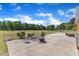 Open patio with outdoor seating and views of the surrounding greenery on a clear, sunny day at 5595 Godwin Lake Rd, Benson, NC 27504