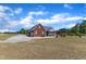 Exterior view of the home, highlighting the screened porch, well-kept lawn, and ample parking space at 5595 Godwin Lake Rd, Benson, NC 27504