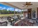Cozy screened-in porch with wicker furniture, stylish decor, and tranquil views of the expansive backyard at 5595 Godwin Lake Rd, Benson, NC 27504