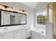 Well-lit bathroom featuring double vanity, garden tub, and glass-enclosed shower at 5745 Spence Farm Rd, Holly Springs, NC 27540