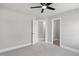 Bedroom with an open door, ceiling fan, and neutral color scheme at 5745 Spence Farm Rd, Holly Springs, NC 27540