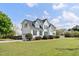 Home's backyard and attached garage, surrounded by lush greenery, under a sunny sky at 5745 Spence Farm Rd, Holly Springs, NC 27540
