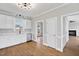Well-lit kitchen with stainless steel dishwasher, white cabinets and hardwood floors at 5745 Spence Farm Rd, Holly Springs, NC 27540