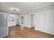 Well-lit kitchen with stainless steel dishwasher, white cabinets and hardwood floors at 5745 Spence Farm Rd, Holly Springs, NC 27540