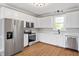 Stylish kitchen boasting stainless steel appliances, white cabinets, and ample counter space at 5745 Spence Farm Rd, Holly Springs, NC 27540