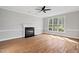 Bright living room with a fireplace, hardwood floors, and a large window at 5745 Spence Farm Rd, Holly Springs, NC 27540