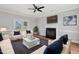 Bright living room features a fireplace, hardwood floors, ceiling fan, and door to the backyard at 5745 Spence Farm Rd, Holly Springs, NC 27540