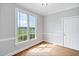 Sunlit room featuring hardwood floors, modern trim and a large window at 5745 Spence Farm Rd, Holly Springs, NC 27540