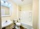 Clean bathroom with a tub, toilet, and a classic pedestal sink with bright vanity lighting at 602 Dexter St, Rocky Mount, NC 27803