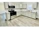 Kitchen featuring white cabinets, modern appliances, and updated floors at 602 Dexter St, Rocky Mount, NC 27803