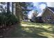 Lush green backyard with mature trees and well-manicured lawn, perfect for outdoor activities at 6521 Vintage Ridge Ln, Fuquay Varina, NC 27526