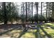 Outdoor relaxation: Backyard fire pit with seating surrounded by mature trees and greenery at 6521 Vintage Ridge Ln, Fuquay Varina, NC 27526
