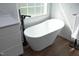 Bright bathroom featuring a modern soaking tub, tile backsplash, and wood look floor at 6521 Vintage Ridge Ln, Fuquay Varina, NC 27526