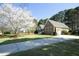 Attractive brick home with attached garage, complemented by mature trees and a long driveway at 6521 Vintage Ridge Ln, Fuquay Varina, NC 27526