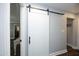 Hallway with a barn door leading to a walk-in pantry and views of the living spaces at 6521 Vintage Ridge Ln, Fuquay Varina, NC 27526