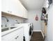 Bright laundry room with white cabinets, sink, stainless faucet, and modern washer and dryer at 6521 Vintage Ridge Ln, Fuquay Varina, NC 27526