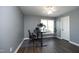 Well lit home office with hardwood floors, neutral walls, and a modern adjustable desk at 6521 Vintage Ridge Ln, Fuquay Varina, NC 27526