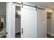 Barn door reveals a walk-in pantry with a refrigerator and ample shelving and storage space at 6521 Vintage Ridge Ln, Fuquay Varina, NC 27526