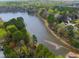 Aerial view showcasing a scenic lake surrounded by lush trees and greenery near residential properties at 7616 Valley Run Dr, Raleigh, NC 27615
