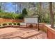Outdoor deck area featuring a detached garage amidst a backdrop of mature trees and greenery at 7616 Valley Run Dr, Raleigh, NC 27615