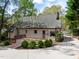 Backyard view showcasing a large wooden deck, fresh landscaping, and a driveway leading to a gated entrance at 7616 Valley Run Dr, Raleigh, NC 27615
