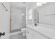 This is a bathroom with a glass shower, white wainscotting, and grey and white tiled floor at 7616 Valley Run Dr, Raleigh, NC 27615