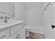 A clean and modern bathroom with subway tile, white fixtures, and brick floor at 7616 Valley Run Dr, Raleigh, NC 27615