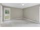 Neutral bedroom featuring two windows, neutral paint and carpet, and ceiling fan at 7616 Valley Run Dr, Raleigh, NC 27615
