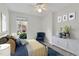 Cozy bedroom featuring a serene blue and gold palette, complemented by nautical-themed artwork and natural light at 7616 Valley Run Dr, Raleigh, NC 27615