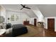 Bedroom featuring hardwood floors, neutral walls, and a dark bed against the backdrop of natural lighting and a ceiling fan at 7616 Valley Run Dr, Raleigh, NC 27615