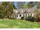 Charming home with white siding, black shutters, dormer windows, brick stairs, and a lush front lawn at 7616 Valley Run Dr, Raleigh, NC 27615
