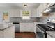 Modern kitchen showcasing white cabinets, stainless steel appliances, and hardwood floors at 7616 Valley Run Dr, Raleigh, NC 27615